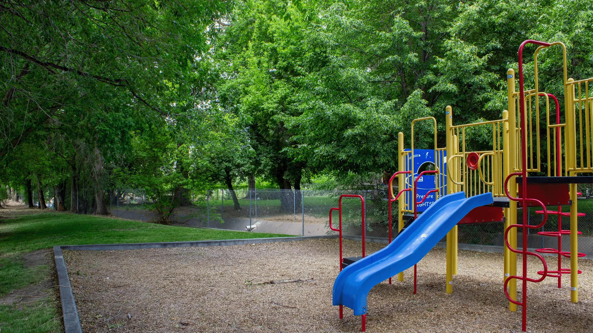Woodside Creek Apartments playground and open grassy area for kids and pets in Bountiful, Utah